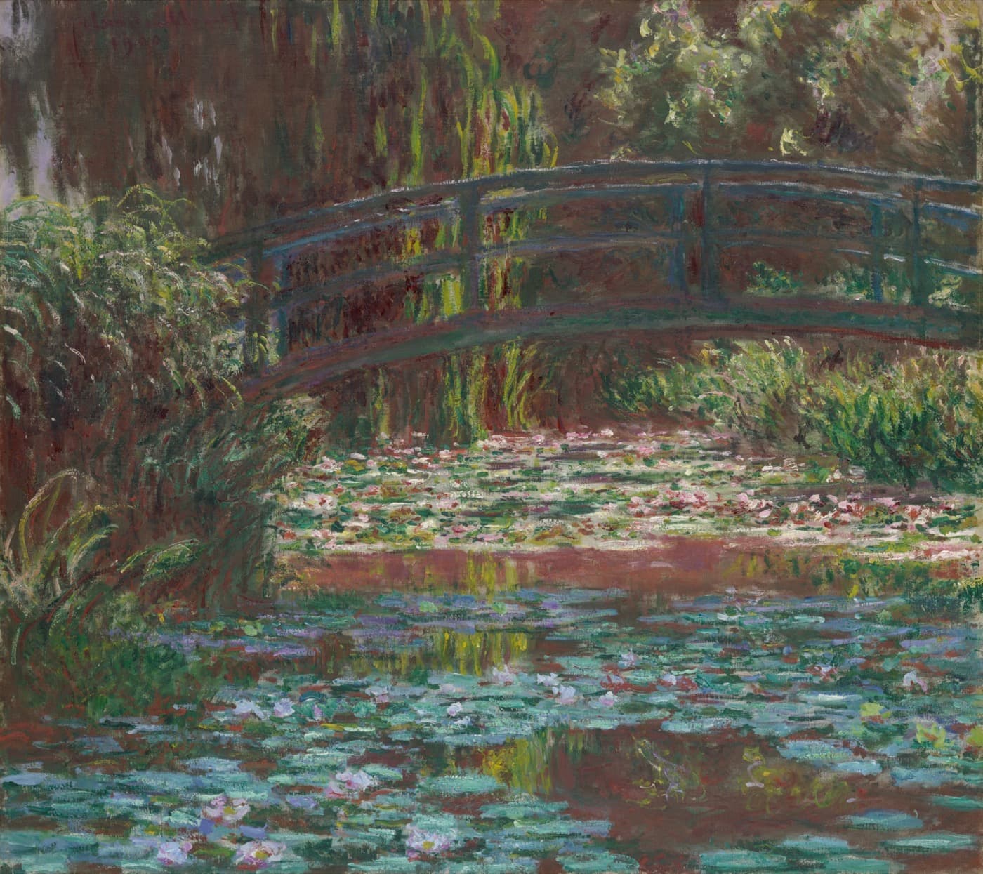 Claude Monet, Water Lily Pond: a green footbridge arches over a pond covered in water lilies.